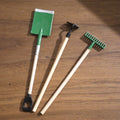 1:12 scale miniature long handle garden tools, shovel, hoe and rake with green heads, set of 3, on a wood surface