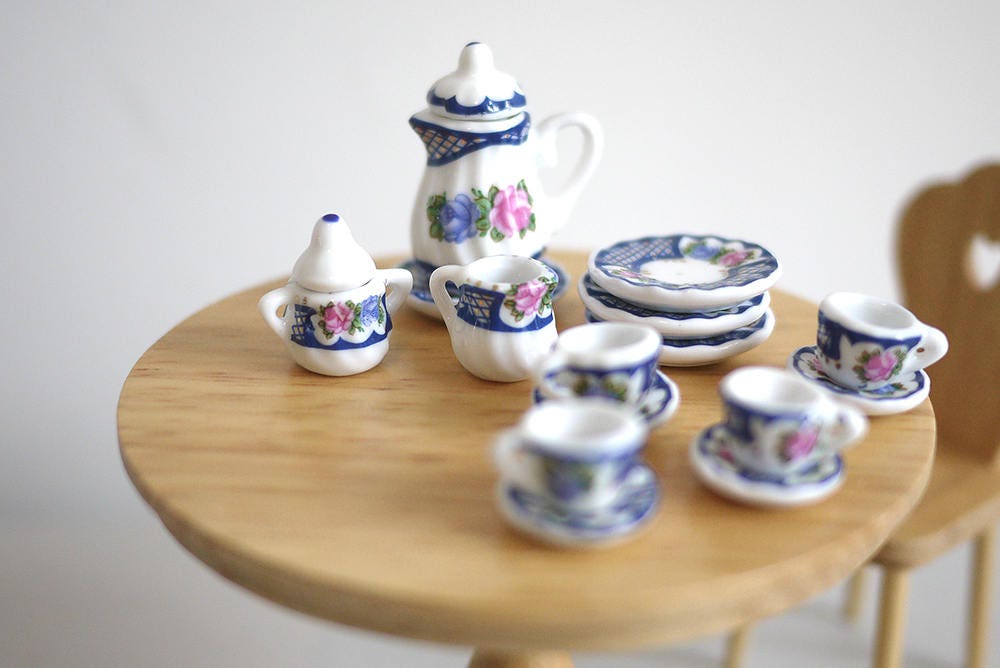 1:12 scale miniature porcelain tea set with blue and red floral pattern, set of 15, on a round wood table
