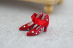 1:12 scale miniature red ankle strap high heel shoes with silver dots, one pair, shown on linen fabric