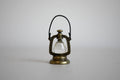1:12 scale miniature metal hurricane oil lantern in antique bronze with wire handle and clear globe, on a gray backdrop