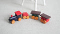 1:12 scale miniature wood toy train, engine and 2 carts in multicolor red, blue, green and yellow, on a white carpet