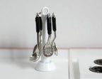 1:12 scale miniature metal cooking utensils with stand, set of 5, silver tools with black handles on a white rack