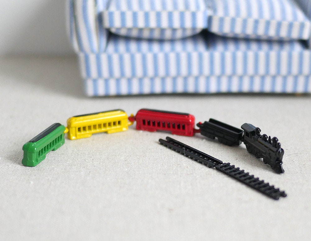 1:12 scale miniature metal toy train with black engine, 3 cars in red, yellow and green and 2 track pieces