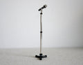 1:12 scale miniature black microphone with tall silver stand and tripod base, shown against a white wall