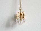 1:12 scale miniature non electric brass chandelier in gold with clear glass drops, shown hanging from its chain