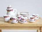 1:12 scale miniature white porcelain tea set with pink floral band, set of 15, teapot, cups and plates on a wood table