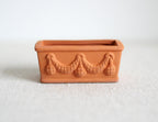 1:12 scale miniature clay rectangular planter with garland relief, unglazed terracotta color, shown on a white surface