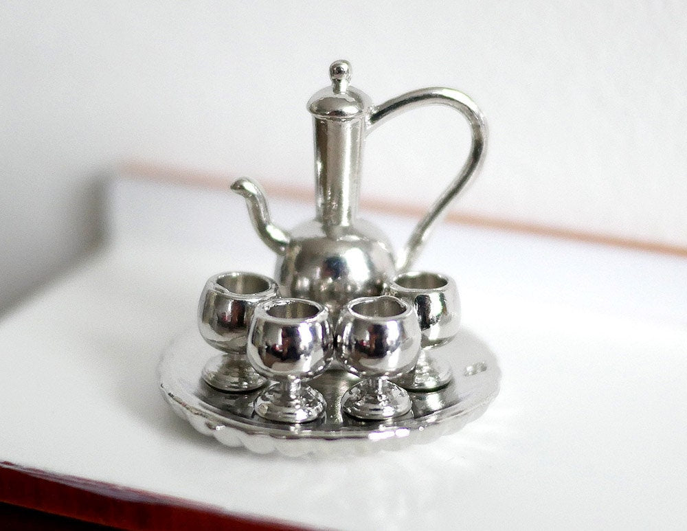 1:12 scale miniature holloware tea set in silver, set of 6 with tall teapot, 4 glasses and round tray, on a white counter