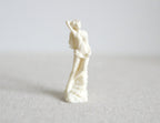 1:12 scale miniature white classical lady statue with raised arm on a rocky base, shown on a light gray surface
