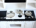 1:12 scale miniature metal frying pans in silver with long handles, set of 3, shown on a white kitchen stove