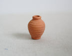 1:12 scale miniature clay urn vase in terracotta with a rounded body and narrow neck, shown on a light surface