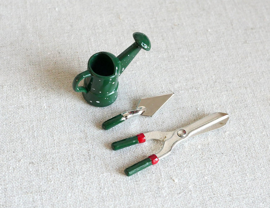 1:12 scale miniature garden tools, green watering can, trowel, hand fork and clippers, set of 4, on a white surface