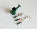 1:12 scale miniature garden tools, green watering can, trowel, hand fork and clippers, set of 4, on a white surface