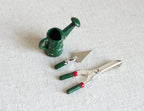 1:12 scale miniature garden tools, green watering can, trowel, hand fork and clippers, set of 4, on a white surface