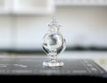 1:12 scale miniature clear glass footed candy jar with pointed lid, shown on a black kitchen counter