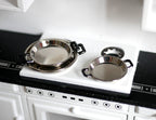 1:12 scale miniature metal cooking pans with side handles in silver, set of 3, shown on a white kitchen stove