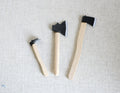 1:12 scale miniature garden tools with wood handles and black heads, axe, hatchet and hoe, set of 3, on linen