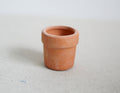 1:12 scale miniature terracotta clay flower pot with rim, empty, shown on a light linen surface