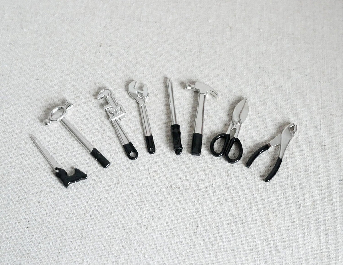 1:12 scale miniature hand tools in black and silver, set of 8, hammer, saw, pliers and wrenches laid out in a row