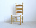 1:12 scale miniature ladder back dining chair with woven seat in a stained finish, shown against a white wall