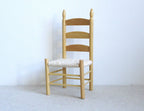 1:12 scale miniature ladder back dining chair with woven seat in a stained finish, shown against a white wall
