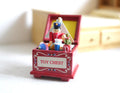 1:12 scale miniature red toy chest with open lid, filled with toys including a toy soldier, on a white floor