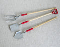 1:12 scale miniature garden tools with wood handles and red grips, set of 3, fork and two shovels on a linen surface