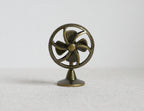1:12 scale miniature metal old style desk fan in antique gold with 4 blades and round cage, on a white surface