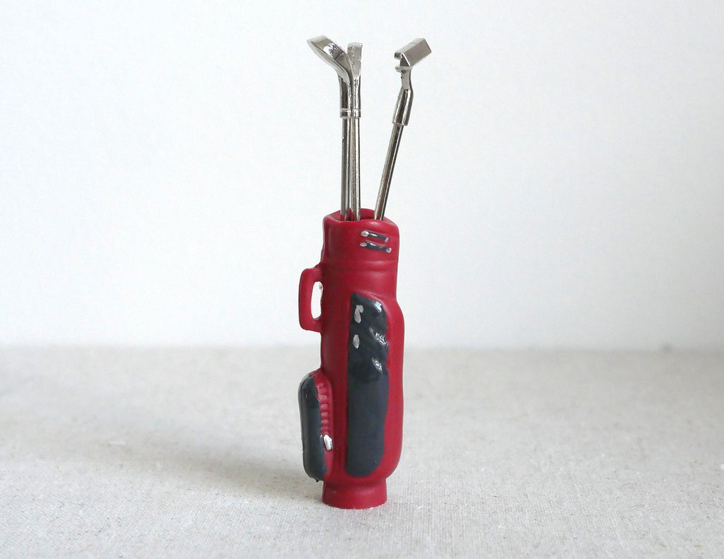 1:12 scale miniature red golf bag with 3 silver clubs, set of 4, standing upright on a white background