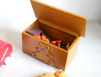 1:12 scale miniature wood bear toy box with opening lid, brown with a teddy bear on the front, shown filled with toys