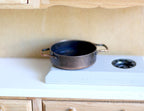 1:12 scale miniature metal saute pan with 2 handles in black, shown on a white stove top