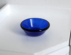 1:12 scale miniature cobalt blue glass round bowl, shallow with a wide rim, shown on a white surface
