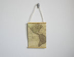 1:12 scale miniature old world map wall scroll with string hanger and wood rods, antique tan map, shown on a wall