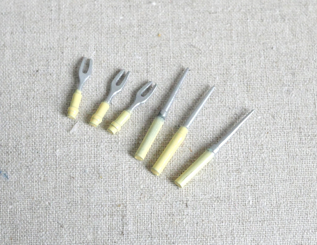 1:12 scale miniature metal BBQ grill tools, set of 6 with pale yellow handles, laid out on linen fabric
