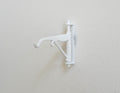 1:12 scale miniature white metal scroll wall bracket with hook arm, shown mounted on a white wall