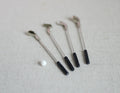 1:12 scale miniature golf clubs with ball, set of 5, silver clubs with black grips and a white ball, on linen