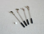 1:12 scale miniature golf clubs with ball, set of 5, silver clubs with black grips and a white ball, on linen