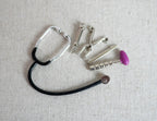 1:12 scale miniature doctor medical tool set with stethoscope, set of 5, silver instruments laid out on linen fabric