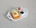 1:12 scale miniature breakfast tray set with fried egg on toast, boiled egg in cup and black coffee on a white tray