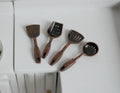 1:12 scale miniature metal cooking utensils with spatulas and skimmers, set of 4, laid out on a white counter