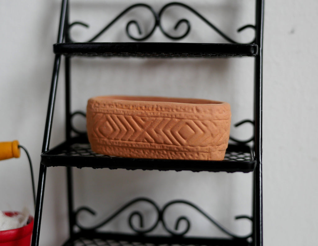 1:12 scale miniature clay oval planter in terracotta with carved lines, shown on a black metal shelf