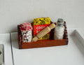 1:12 scale miniature dark brown wood kitchen wall shelf with rail, holding jars, a box and a rolling pin