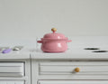 1:12 scale miniature pink metal cooking pot with lid, 2 side handles and a wood knob, shown on a white kitchen counter