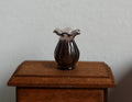 1:12 scale miniature translucent vase with ruffled top in smoky brown, shown on a dark wood side table