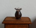 1:12 scale miniature translucent vase with ruffled top in smoky brown, shown on a dark wood side table