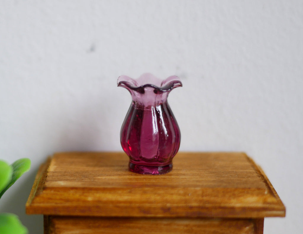 1:12 scale miniature purple vase with scalloped rim and ribbed body, translucent, shown on a wood nightstand