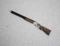 1:12 scale miniature hunting rifle display decoration with brown stock and black barrel, on a light surface