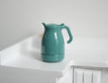 1:12 scale miniature teal metal water kettle with removable lid and curved handle, shown on a white counter