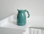 1:12 scale miniature teal metal water kettle with removable lid and curved handle, shown on a white counter