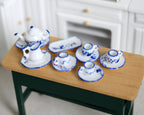 1:12 scale miniature porcelain tea set with cups, saucers and tray, blue floral pattern, set of 13, shown on a wood table